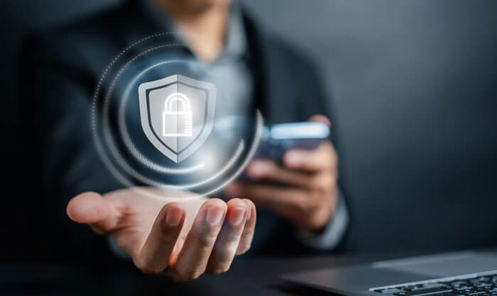 A man holding out his hand. A shield and padlock graphic symbolizing security is placed in the palm.